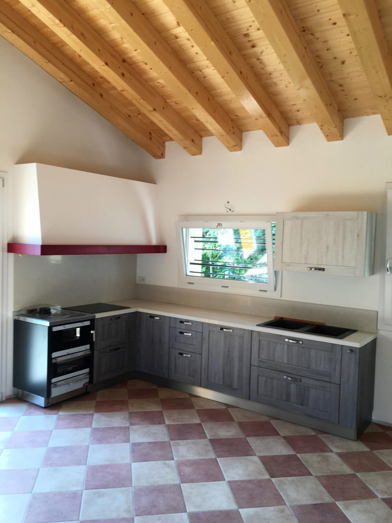 Cucina con cappa su misura con trave rosso - Abitazione privata a Crocetta del Montello vicino Montebelluna